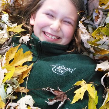 Fernwood Cove Camper playing in the fall leaves